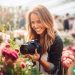 A photographer taking a close-up shot of some flowers at a wedding.