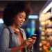 A woman at the grocery store that is looking at an app on her phone that gives her deals on her groceries.