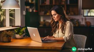 A brunette woman typing on her laptop at home.
