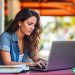 A freelance writer working on her computer in an outdoor cafe.