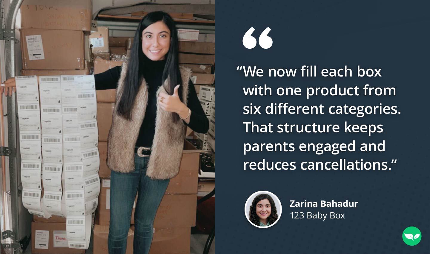 Zarina Bahadur standing in a storage area, smiling while holding a long sheet of shipping labels, with stacked boxes behind her.