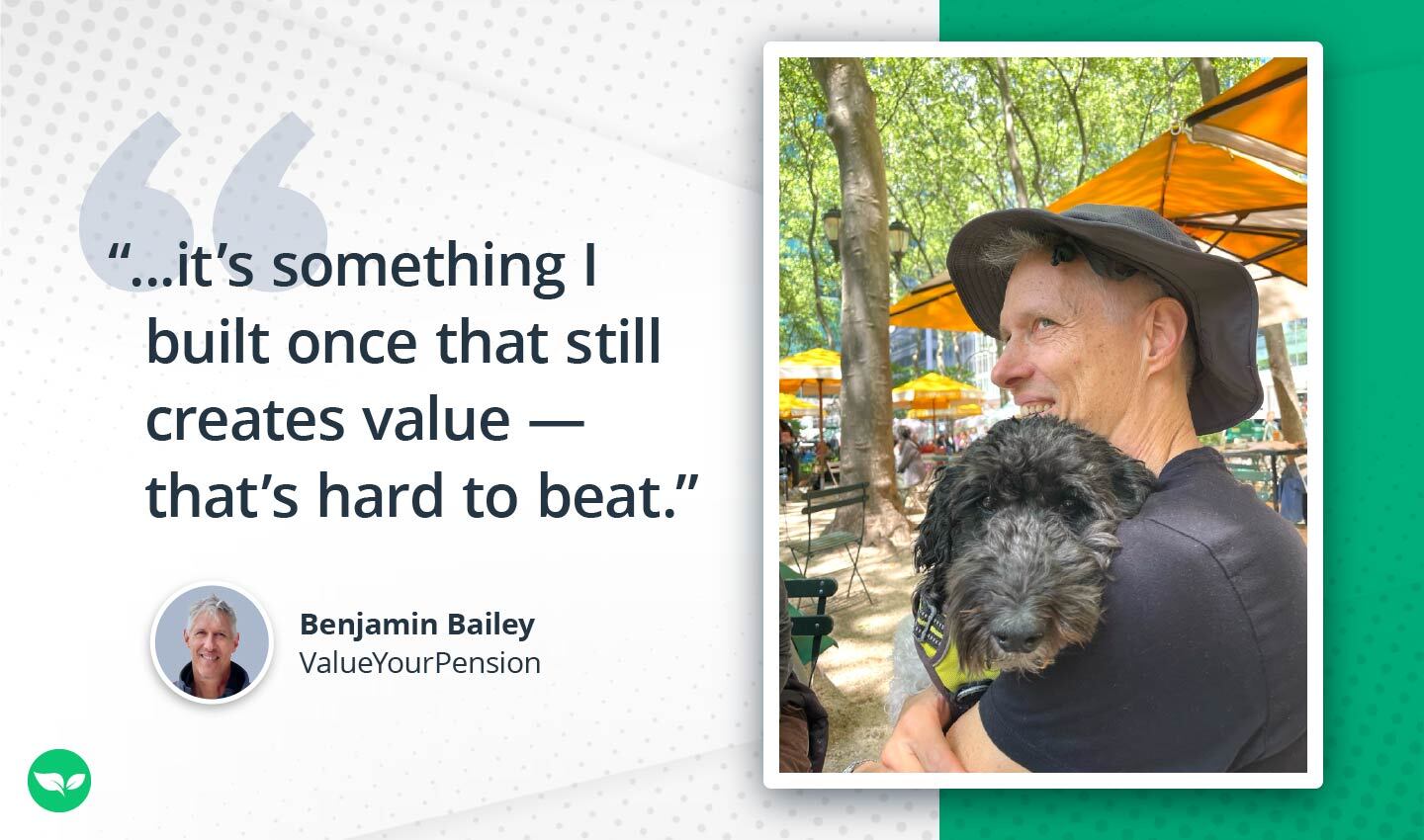 Benjamin Bailey smiling while holding his black poodle at an outdoor café with orange umbrellas in the background.