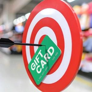 Bullseye target with a green gift card and black arrow, symbolizing hitting your goal with free Target gift cards.