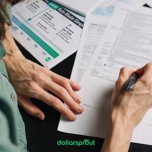 Person reviewing tax paperwork at a desk with a printed $400 Rule Made Simple chart nearby, illustrating when side hustlers owe self-employment tax. The image represents organizing finances and understanding the $400 tax threshold for freelancers and gig workers.