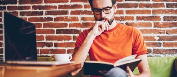 man reading a book about how to get out of debt